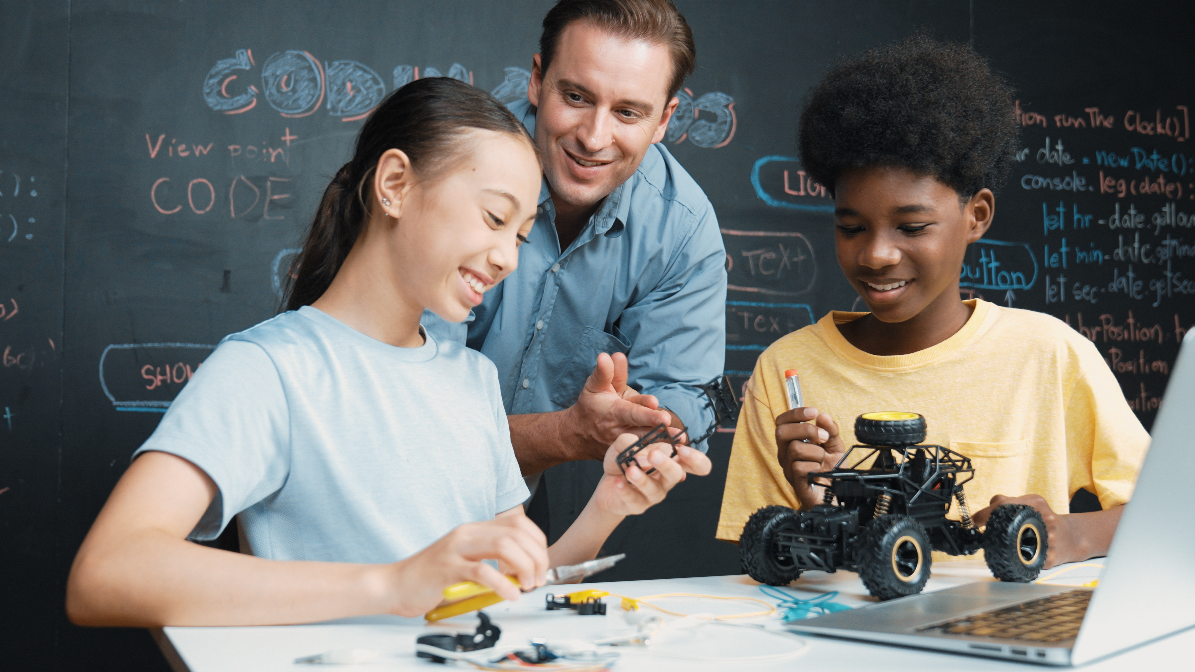 Professor e alunos em aula de robótica educacional